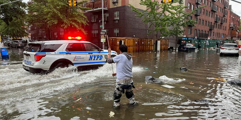 Ein Mann versucht im Stadtbezirk Brooklyn,  einen Abfluss im Hochwasser zu reinigen. Inzwischen ist das Wasser wieder versickert. - Foto: Jake Offenhartz/AP/dpa