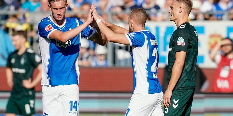 Tim Skarke (M) feiert mit Christoph Klarer (l) den ersten Darmstädter Saisonsieg. - Foto: Uwe Anspach/dpa