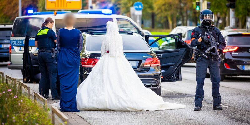 Polizisten kontrollieren Teilnehmer eines Hochzeitskorsos und ihre Fahrzeuge. - Foto: Moritz Frankenberg/dpa