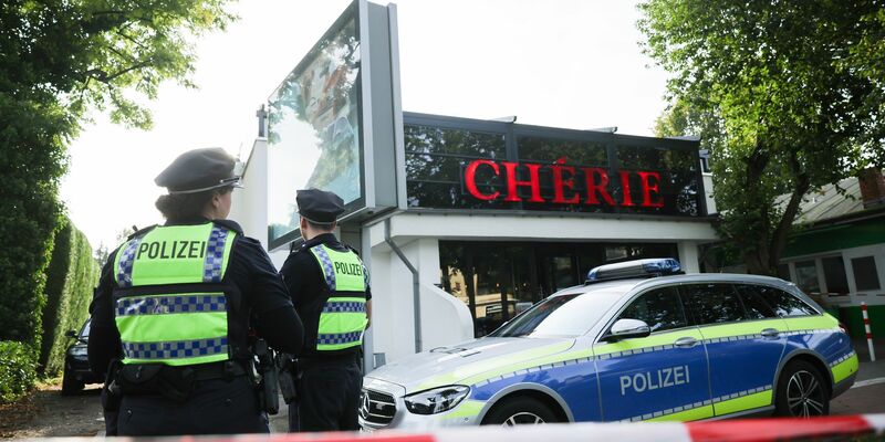 Polizeibeamte stehen vor der Shisha-Bar in Hamburg, wo ein 24-Jähriger erschossen worden war. - Foto: Christian Charisius/dpa