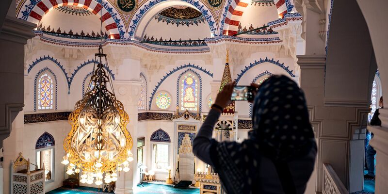 Eine Besucherin fotografiert die Sehetlik-Moschee am Columbiadamm in Berlin. - Foto: Fabian Sommer/dpa