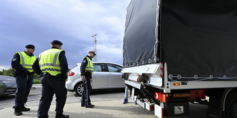 Polizisten kontrollieren einen Lastwagen und Autofahrer am Grenzübergang Berg in Österreich. - Foto: Hans Klaus Techt/APA/dpa