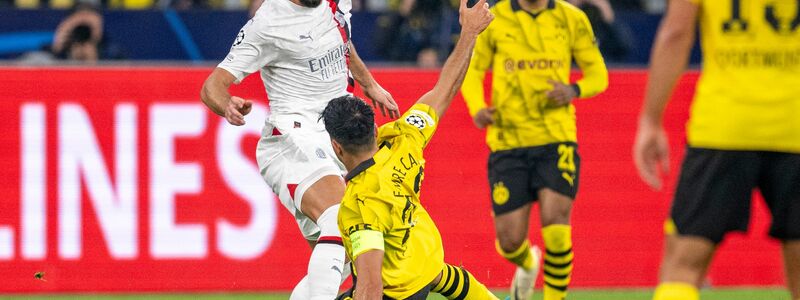 BVB-Kapitän Emre Can versucht Milans Olivier Giroud (l.) den Ball abzugrätschen. - Foto: David Inderlied/dpa