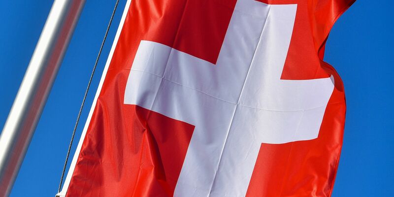 Die Nationalflagge der Schweiz weht vor blauem Himmel. In Zürich kam es zu einem gefährlichen Zwischenfall. - Foto: Patrick Pleul/dpa-Zentralbild/dpa