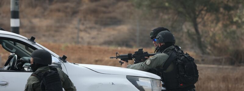 Israelische Streitkräfte gehen hinter einem Fahrzeug in der Grenzstadt Sderot in Stellung. - Foto: Ilia Yefimovich/dpa