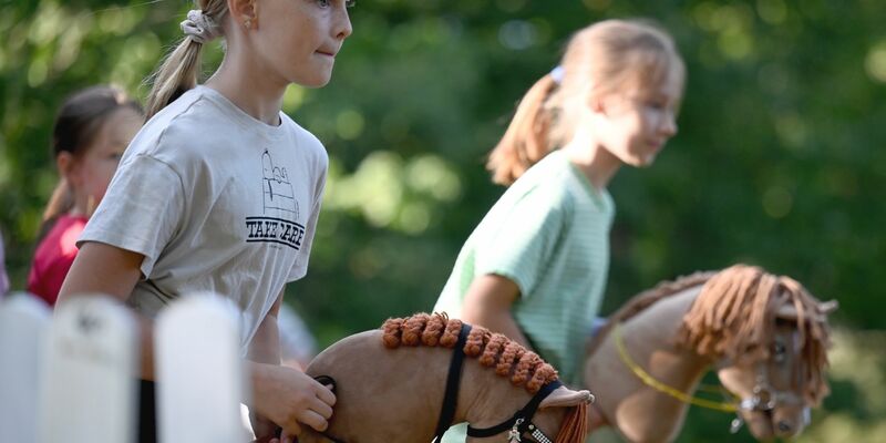 Zwei Mädchen beim Hobby Horsing-Kurs im Berliner Volkspark Wuhlheide. - Foto: Carla Benkö/dpa