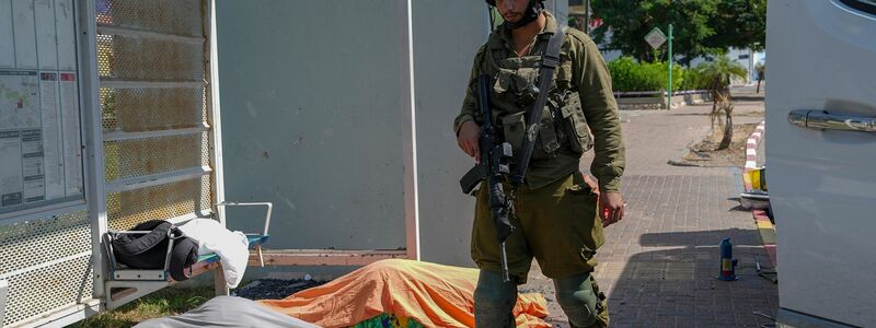 Ein israelischer Soldat steht in Sderot neben den Leichen von Israelis, die von Hamas-Kämpfern getötet wurden. - Foto: Tsafrir Abayov/AP/dpa