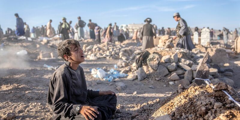 Ein Junge trauert neben dem Grab seines kleinen Bruders, der in der Provinz Herat im Westen Afghanistans ums Leben gekommen ist. - Foto: Ebrahim Noroozi/AP/dpa