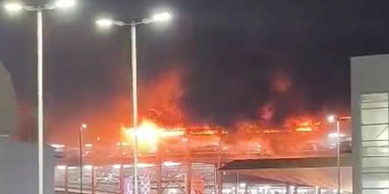 Flammen schlagen aus der obersten Etage eines mit vielen Autos besetzten Parkhauses am Londoner Flughafen Luton (Screenshot aus einem bei X geposteten Video). - Foto: @Soriyn23/PA Media/dpa