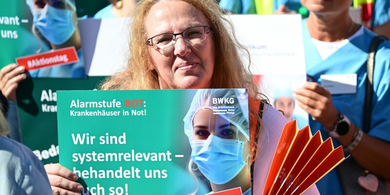 Mitarbeiter und Mitarbeiterinnen von Krankenhäusern protestieren am 20.09.2023 auf dem Schlossplatz in Stuttgart. Nach einer Umfrage unter den 600 größten deutschen Kliniken aus dem Sommer schreibt über die Hälfte rote Zahlen. - Foto: Bernd Weißbrod/dpa