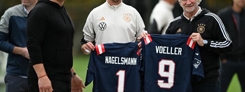 Julian Nagelsmann und Sportdirektor Rudi Völler mit Trikots der New England Patriots. - Foto: Federico Gambarini/dpa