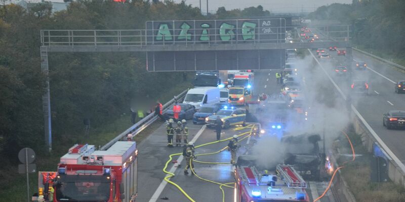 Zahlreiche Einsatzkräfte der Feuerwehr bei Löscharbeiten an einem brennenden Fahrzeug auf der A5. - Foto: Rene Priebe/dpa