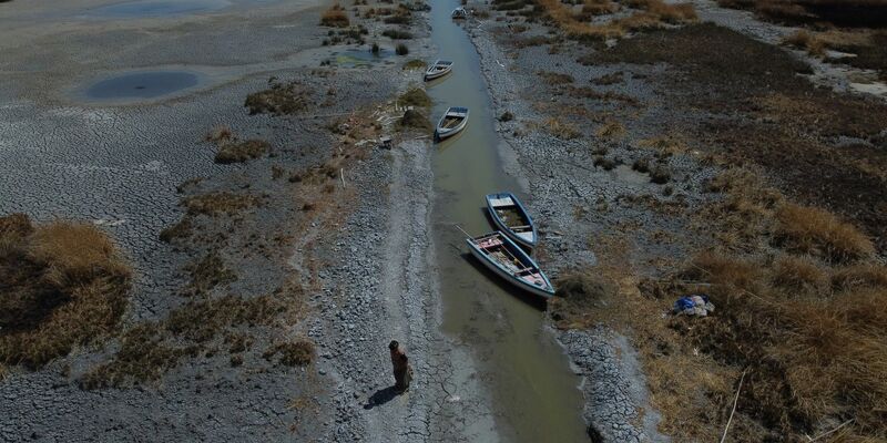 Boote an einem fast ausgetrockneten Ufer des Titicacasees nahe der Ortschaft Huarina in Bolivien. - Foto: Alexis Gomez/dpa