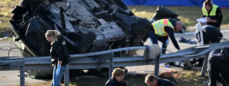 Rettungskräfte und Polizisten am umgestürzten Fahrzeug. Beim Unfall sind sieben Menschen gestorben und mehrere schwer verletzt worden. - Foto: Sven Hoppe/dpa