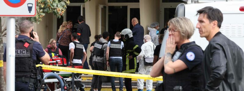 Französische Polizeibeamte des forensischen Dienstes stehen vor dem Gambetta-Gymnasium in Arras. Ein Messerangreifer hat dort mindestens einen Menschen getötet. - Foto: Denis Charlet/AFP/dpa