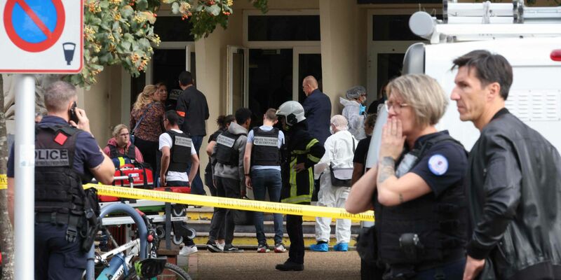 Französische Polizeibeamte des forensischen Dienstes stehen vor dem Gambetta-Gymnasium in Arras. Ein Messerangreifer hat dort mindestens einen Menschen getötet. - Foto: Denis Charlet/AFP/dpa