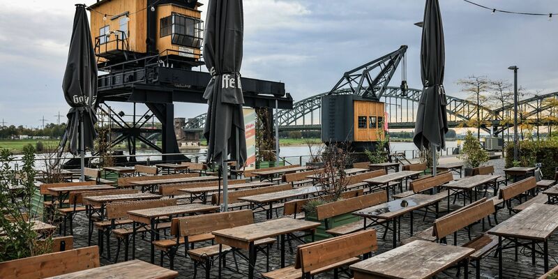 Leere Tische und Bänke am Rheinauhafen in Köln. - Foto: Oliver Berg/dpa