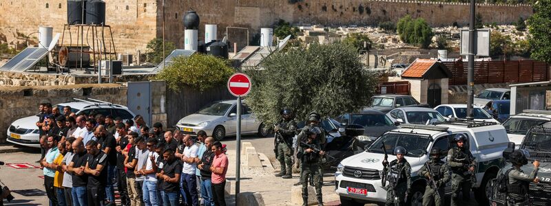 Palästinensische Gläubige beten außerhalb der Altstadt von Jerusalem, während israelische Streitkräfte Wache stehen. - Foto: Oren Ziv/dpa