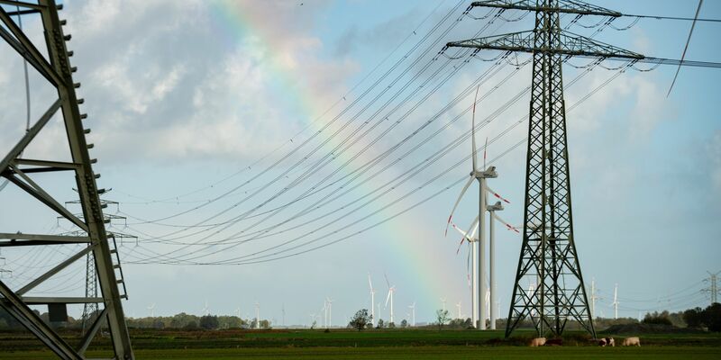 Ein Regenbogen zwischen Hochspannungsmasten und Windrädern in Schleswig-Holstein. Die für die Energiewende wichtige Westküstenleitung von der dänischen Grenze bis Brunsbüttel hat ihren Betrieb aufgenommen. - Foto: Jonas Walzberg/dpa