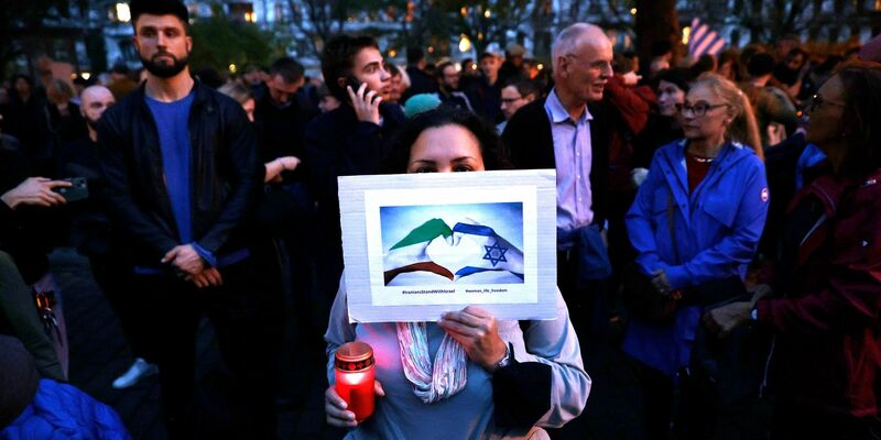 Menschen nehmen vor der Synagoge am Berliner Fraenkelufer an einer Mahnwache teil. - Foto: Carsten Koall/dpa