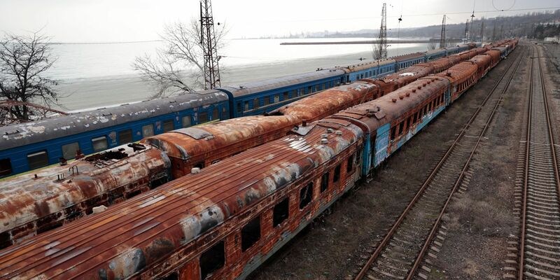 Ausgebrannte Waggons am Bahnhof in Mariupol. Russland soll an einer neuen Bahnstrecke in die Küstenstadt arbeiten (Archivbild). - Foto: Alexei Alexandrov/AP/dpa