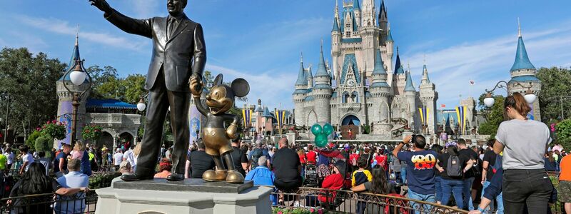 Eine Statue von Walt Disney und Micky Maus  vor dem Cinderella-Schloss im Magic Kingdom von Walt Disney World in Florida. - Foto: John Raoux/AP/dpa