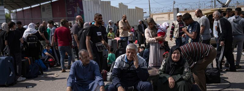 Palästinenser warten am Grenzübergang Rafah auf die Einreise nach Ägypten. - Foto: Fatima Shbair/AP/dpa
