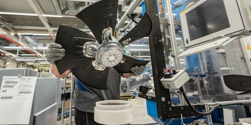 Ein Mitarbeiter eines Herstellers von Ventilatoren und Elektromotoren montiert einen Lüfter. - Foto: picture alliance / Daniel Maurer/dpa