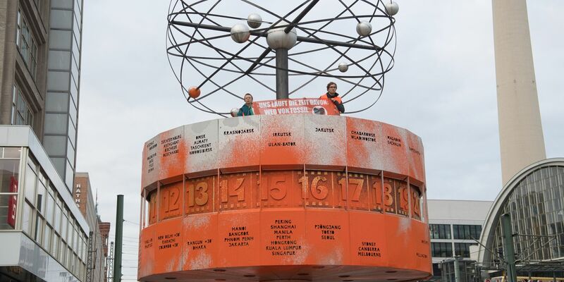 Aktivisten der Gruppe Letzte Generation haben die Weltzeituhr am Alexanderplatz orange eingefärbt. - Foto: Paul Zinken/dpa