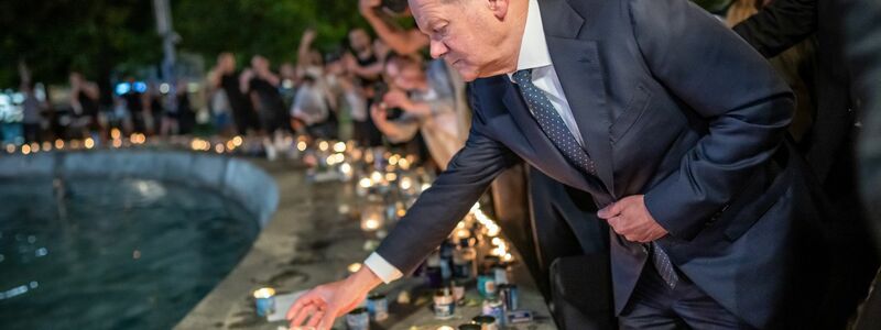 Bundeskanzler Olaf Scholz (SPD) steht bei seinem Solidaritätsbesuch in Israel mit einer Kerze am Dizengoff Square im Zentrum von Tel Aviv. - Foto: Michael Kappeler/dpa Pool/dpa