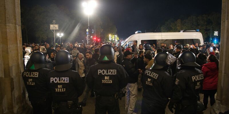 Palästinenser sowie deren Unterstützer streiten sich mit der Polizei vor dem Brandenburger Tor. - Foto: Paul Zinken/dpa