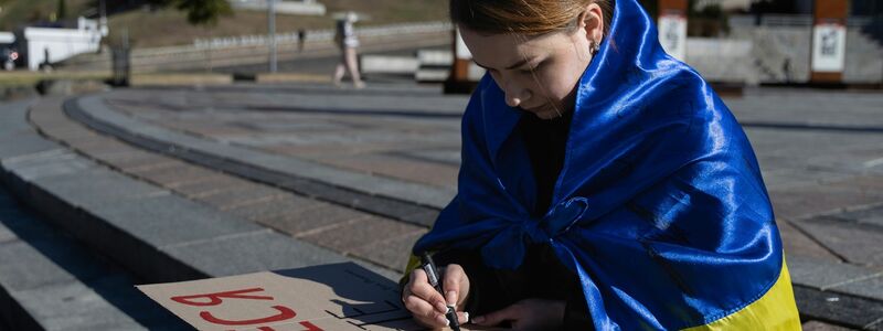 Eine Studentin in Kiew schreibt die ersten Worte des ukrainischen Gedichts «Kämpfe weiter - du wirst siegen» von Taras Schewtschenko auf ein Plakat. - Foto: Alex Babenko/AP/dpa