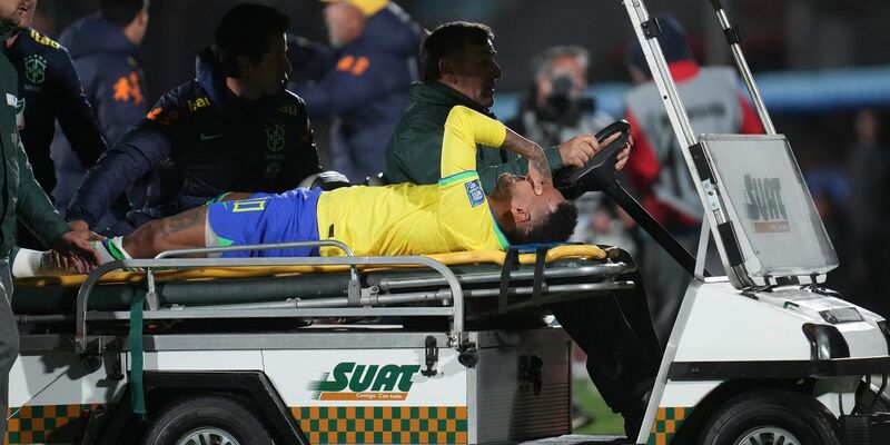Brasiliens Neymar wird vom Spielfeld gefahren. Im WM-Qualifikationsspiel in Uruguay hat sich der Spieler das vordere Kreuzband sowie den Meniskus im linken Knie gerissen. - Foto: Matilde Campodonico/AP