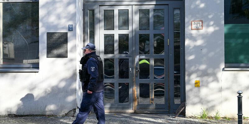 Ein Polizeibeamter geht an der Synagoge an der Brunnenstraße 33 in Berlin entlang, die Ziel eines Anschlags war. - Foto: Soeren Stache/dpa