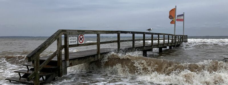 Ein Badesteg in Niendorf wird von Wellen umspült. An der schleswig-holsteinischen Ostseeküste wird eine schwere Sturmflut erwartet. - Foto: Thomas Müller/dpa