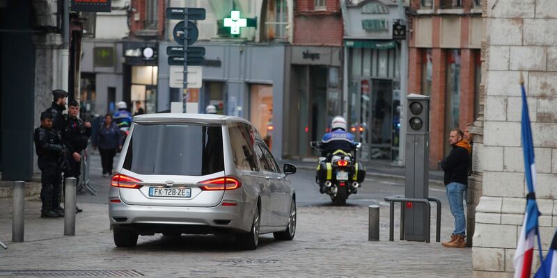 Der Leichenwagen mit dem Sarg des getöteten französischen Lehrers folgt einer Polizeieskorte. - Foto: Michel Spingler/AP /dpa