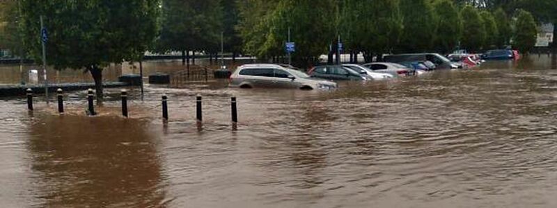 Autos in Kork stehen halb unter Wasser. - Foto: Maria Kring/PA Media/dpa