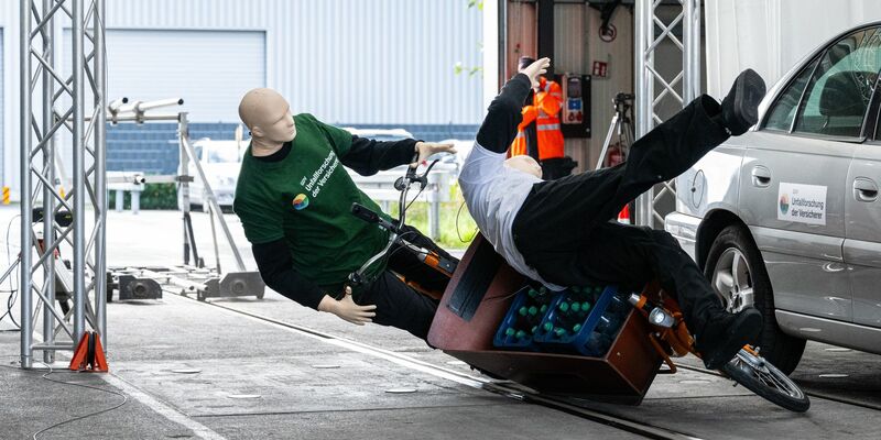 Bei einem Crashtest stoßen ein Lastenfahrrad und ein Fußgänger zusammen. - Foto: Guido Kirchner/dpa