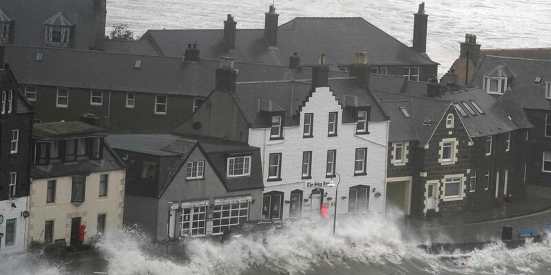 Hohe Wellen brechen an einer Kaimauer an der schottischen Nordseeküste. - Foto: Andrew Milligan/PA Wire/dpa