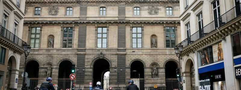 Polizeibeamte stehen vor dem Louvre Wache, nachdem das Museum wegen einer Bombendrohung geräumt wurde. - Foto: Thomas Padilla/AP/dpa