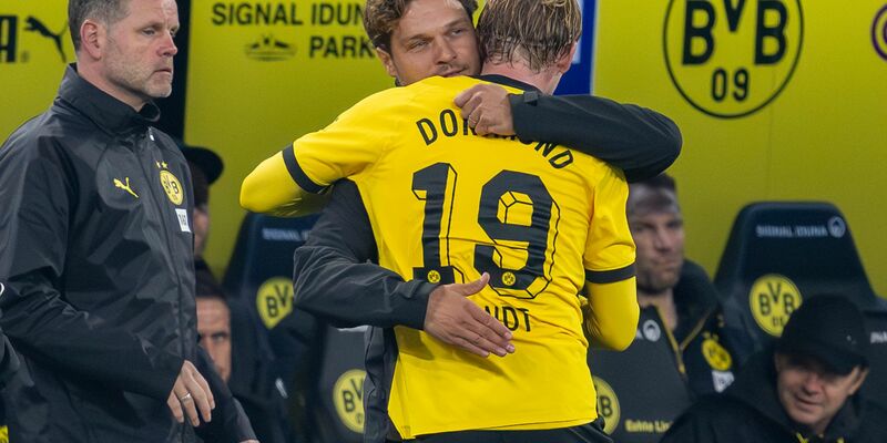 BVB-Trainer Edin Terzic umarmt Matchwinner Julian Brandt. - Foto: David Inderlied/dpa