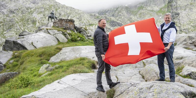 SVP-Präsident Marco Chiesa (r) und Vizepräsident Marcel Dettlig posieren mit einer Nationalflagge. - Foto: Urs Flüeler/KEYSTONE/dpa