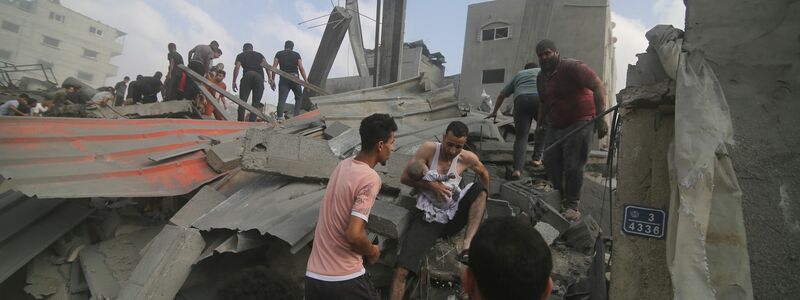 Palästinenser betrachten die Zerstörung nach einem israelischen Angriff. - Foto: Hatem Ali/AP/dpa