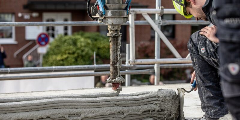 Ein Arbeiter inspiziert die Baustelle eines Mehrfamilienhauses aus dem 3D-Drucker. - Foto: Dieter Menne/dpa