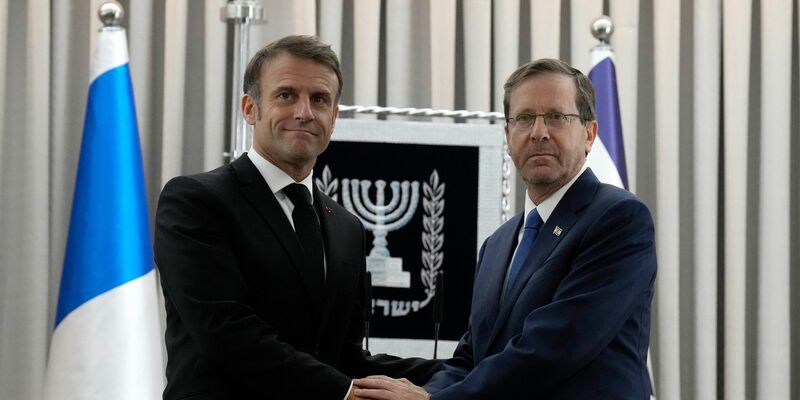 Emmanuel Macron (l), Präsident von Frankreich, schüttelt Izchak Herzog, Präsident von Israel, die Hand. Frankreichs Präsident Macron ist zu einem zweitägigem Besuch in Israel. - Foto: Christophe Ena/AP Pool/dpa