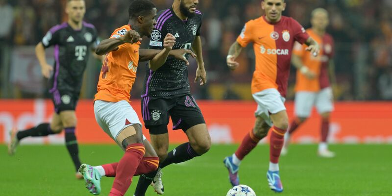 Noussair Mazraoui vom FC Bayern München (M) im Duell mit Wilfried Zaha von Galatasaray Istanbul. - Foto: Peter Kneffel/dpa