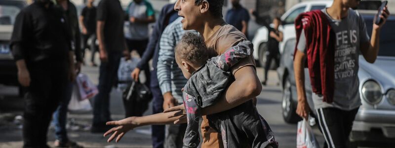 Ein Mann trägt nach einem israelischen Luftangriff auf Gaza-Stadt ein verletztes Kind auf dem Arm. - Foto: Mohammed Abu Elsebah/dpa