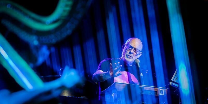 Brian Eno tritt mit dem Baltic Sea Philharmonic Orchester unter Dirigent Kristjan Järvi in der Berliner Philharmonie auf. - Foto: Christoph Soeder/dpa