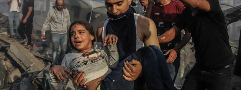 Palästinenser retten ein junges Mädchen aus den Trümmern eines zerstörten Gebäudes nach einem israelischen Luftangriff. - Foto: Mohammed Abu Elsebah/dpa