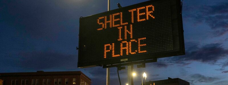 Ein Schild rät Anwohnerinnen und Anwohnern, zu Hause zu bleiben. - Foto: Robert F. Bukaty/AP/dpa